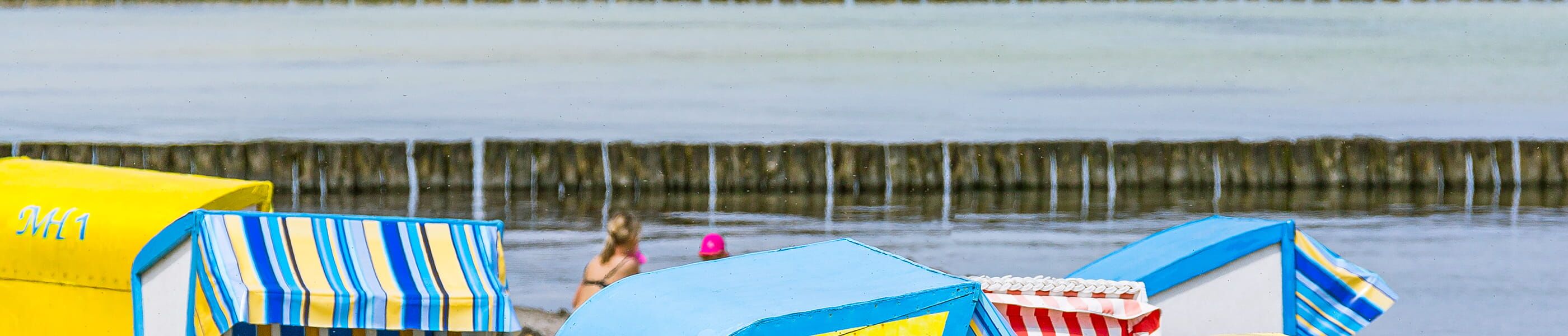 bunte Strandkörbe vor der Ostsee