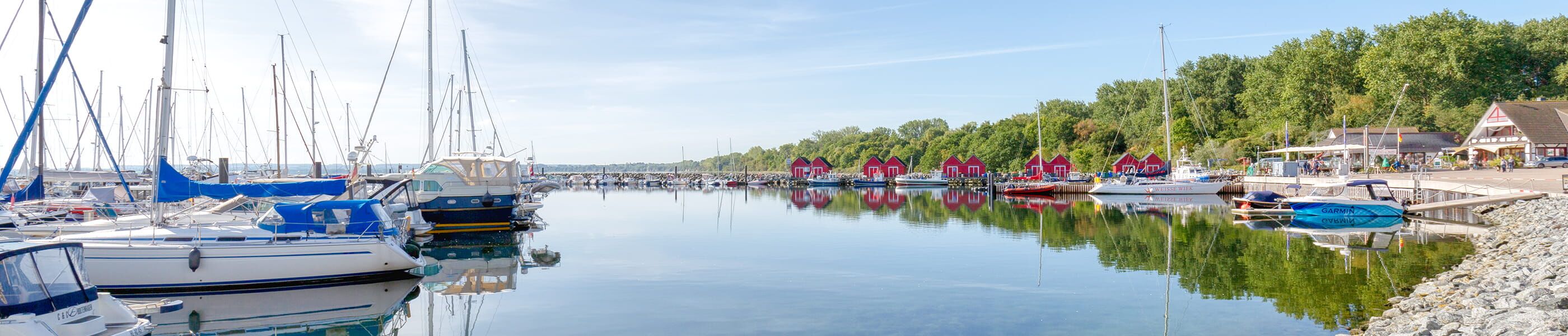 Yacht- und Fischereihafen mit Segelbooten und roten Häusern